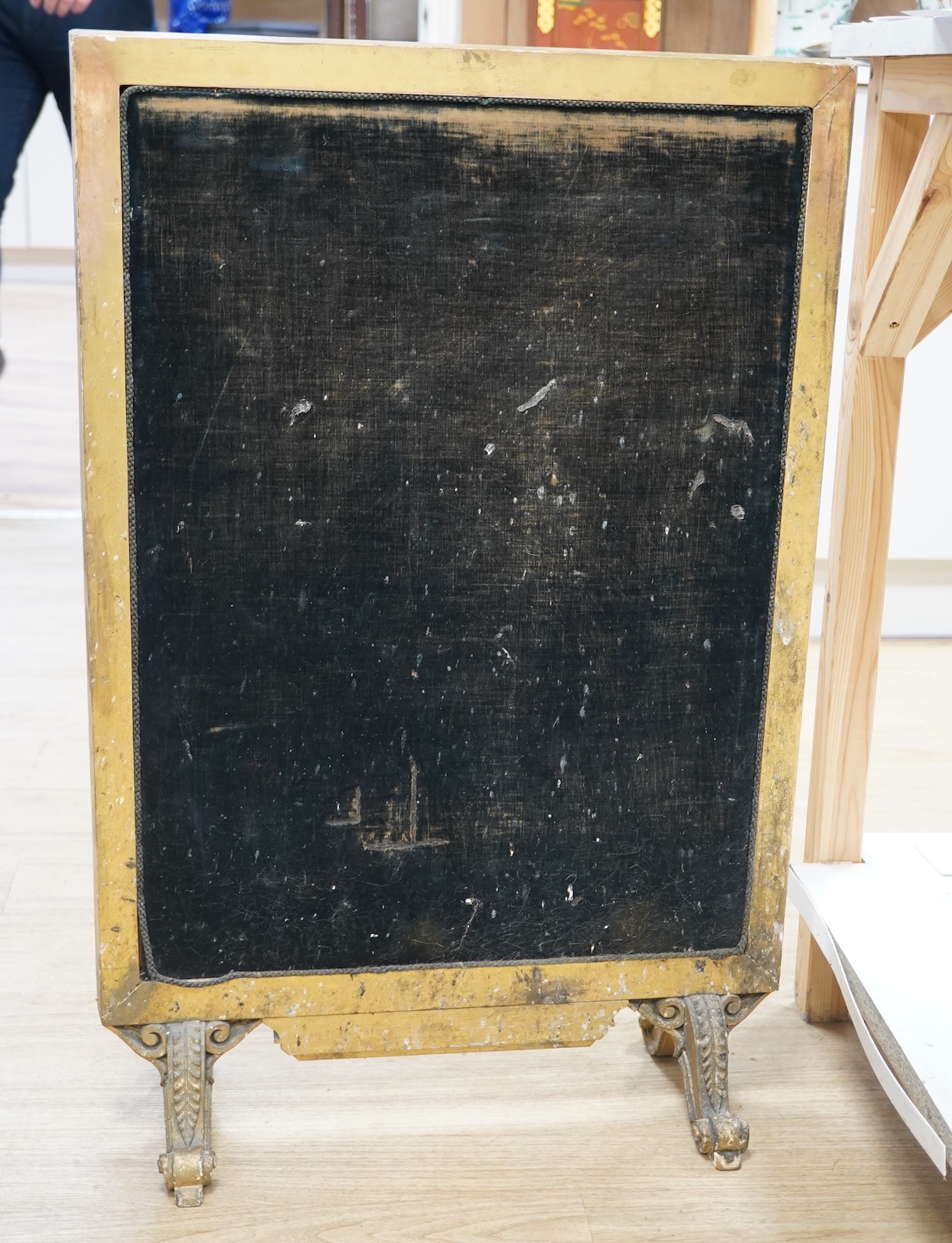 A late 19th century gilt framed silk and wool work embroidered fire screen, embroidered with a central sprig of poppies, wheat and wild flowers in a circular border of similar flowers, the frame with a decorative carved